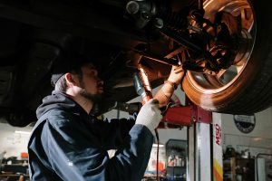 mechanic working on a car elevated on a lift