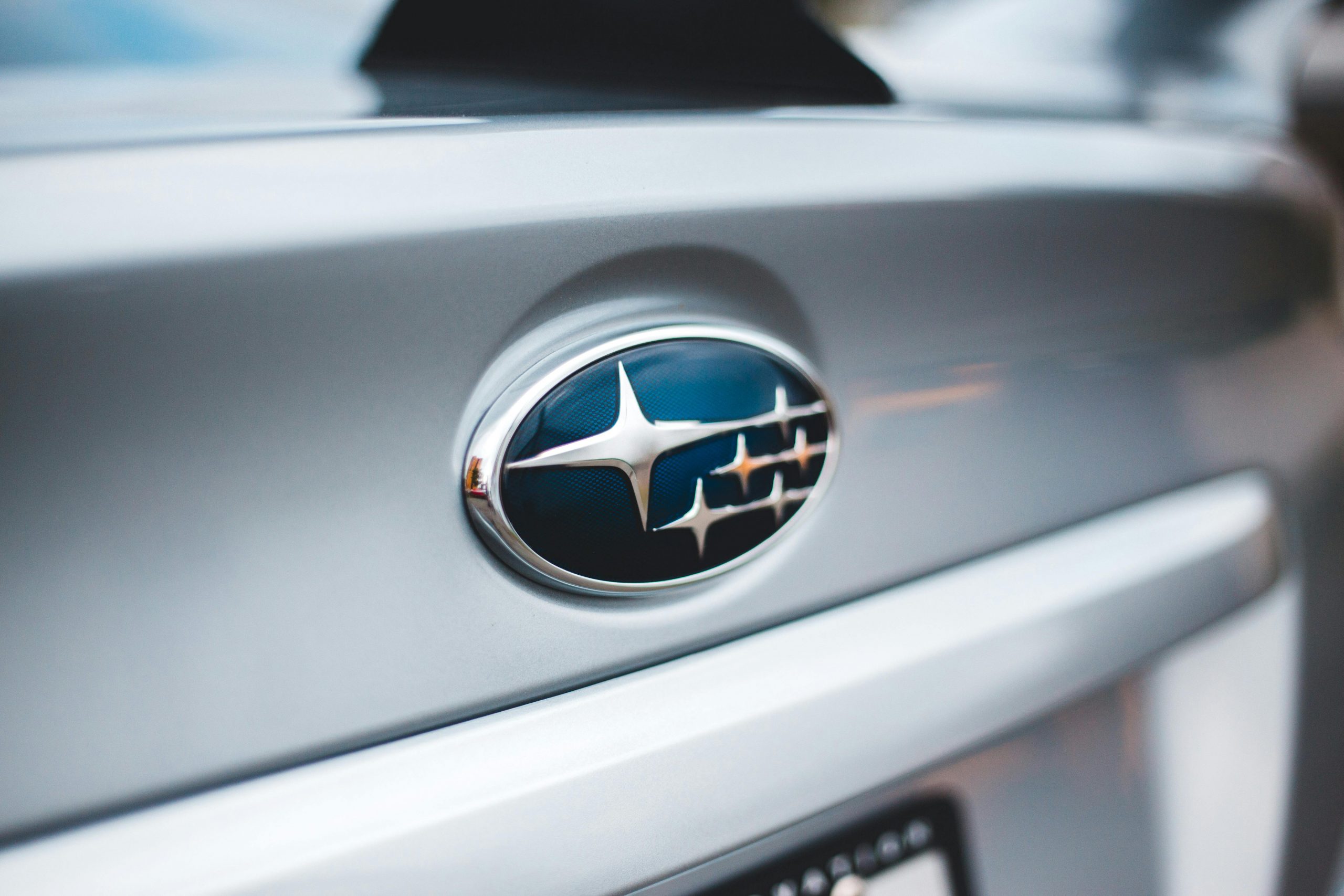 close-up of the Subaru logo on the trunk of a silver car