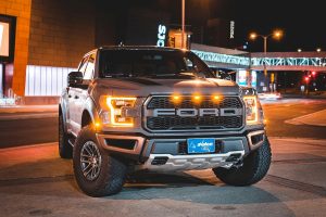 black Ford pickup parked on a road at night