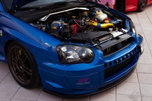 blue Subaru with its hood open, exposing the engine