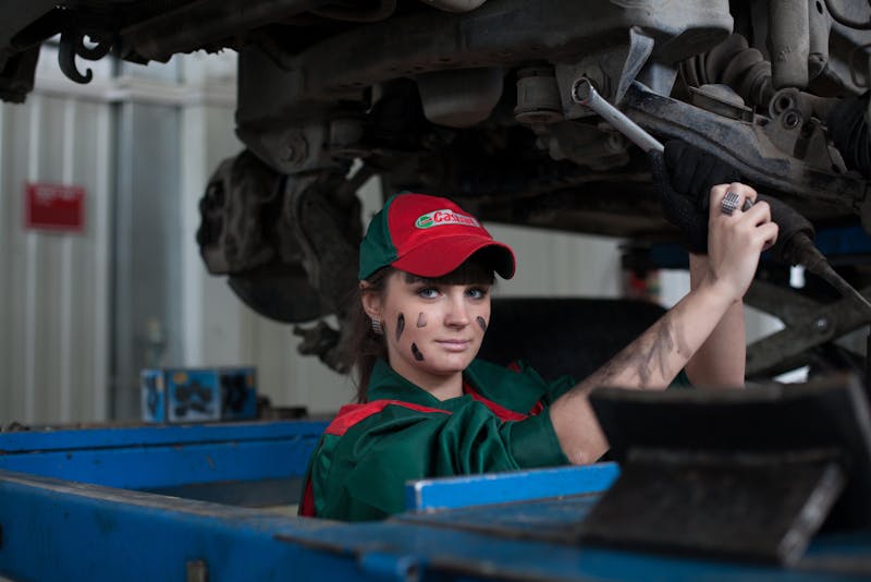 a lady mechanic working on a car